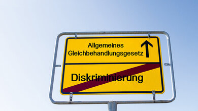 Fotomontage: Ortsschild mit Aufschrift „Allgemeines Gleichbehandlungsgesetz“