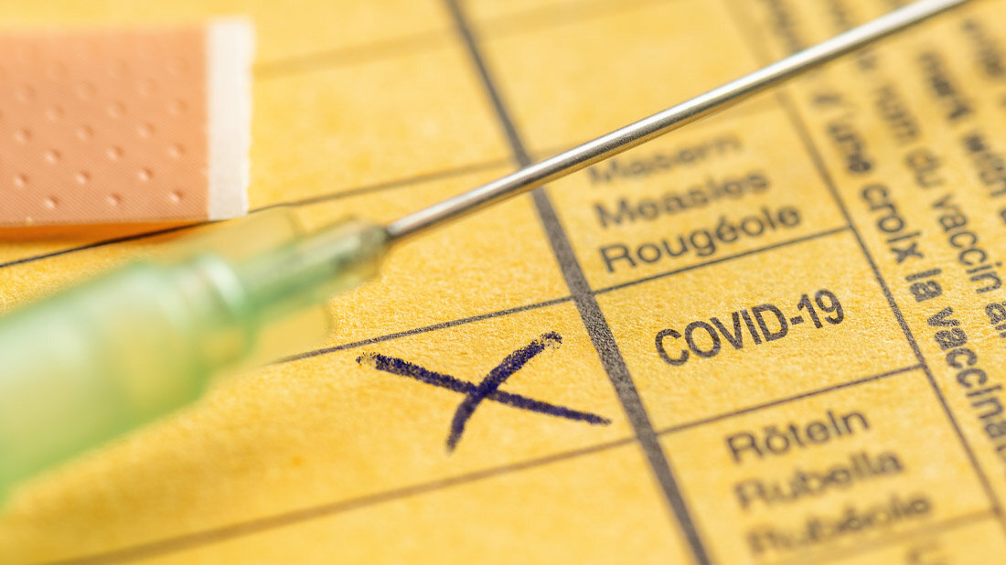 Impfheft, bei dem eine Impfung gegen COVID-19 angekreuzt ist.