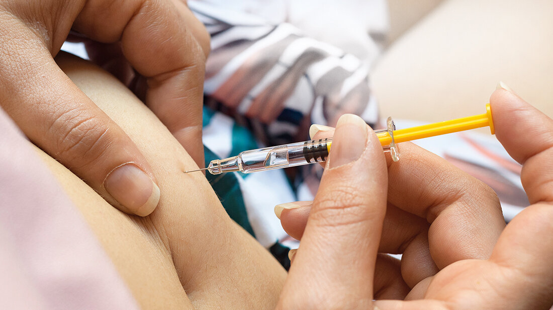 Foto vom Einstich einer Spritze in den Bauch.