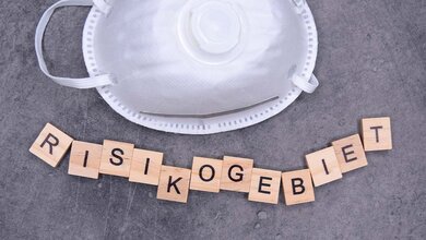 Maske_AdobeStock_386236670_edited.jpg FFP2 Maske und Buchstaben Risikogebiet