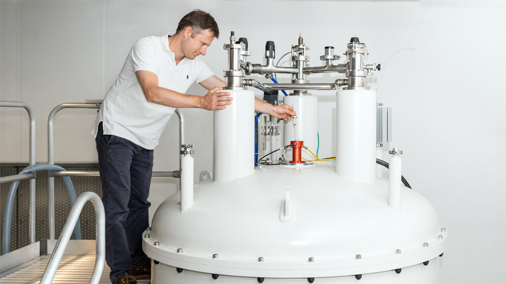 Prof_Franz_Hagn_mit_Kernspinresonanzspektroskopie_Probe_Uli_Benz_TUM.jpg Prof. Franz Hagn