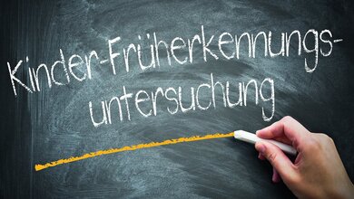 Schultafel mit dem Begriff „Kinder-Früherkennungsuntersuchung“