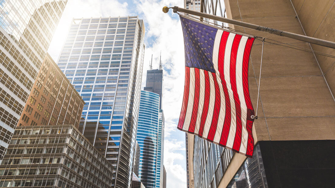 US-Flagge vor Hochhäusern