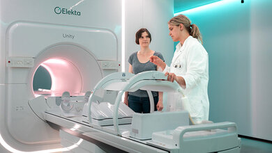 Ärztin erläutert Patientin vor einer Kombi-Röhre für MRT und Strahlentherapie, MR-Linac, Aspekte der Strahlentherapie