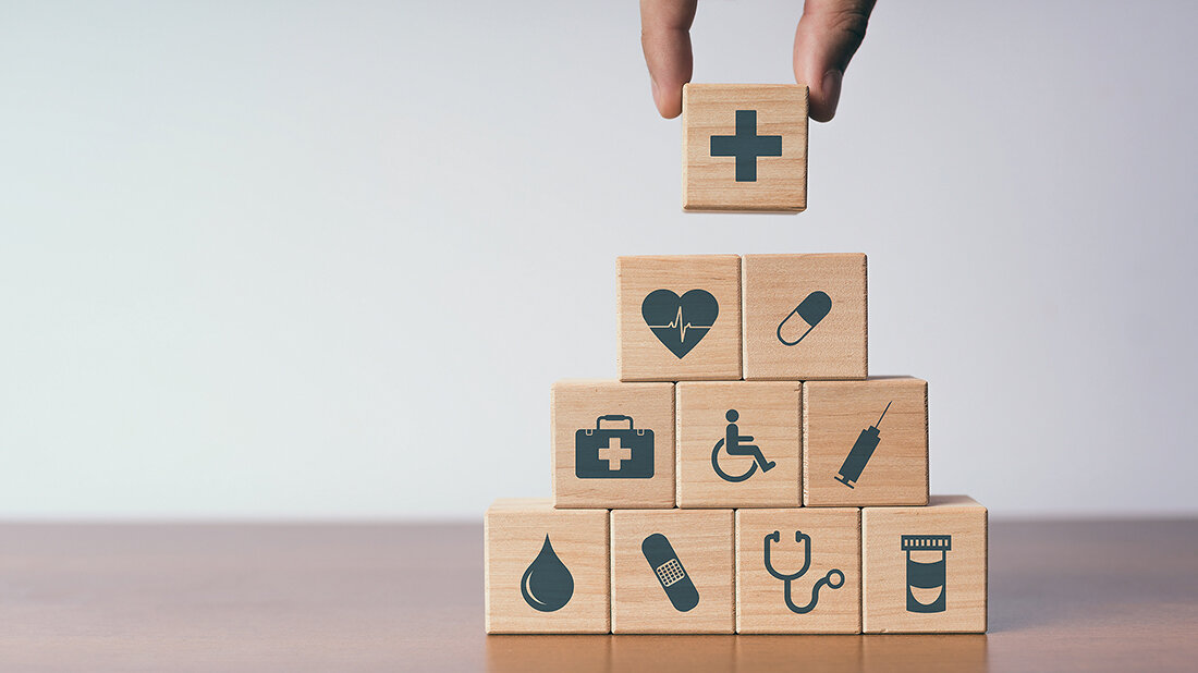 Fachberufekonferenz der Bundesärztekammer: Fokus auf Prävention und Förderung der Gesundheitskompetenz richten Foto auf dem auf einen Stapel Holzwürfel der abschließende letzte gelegt wird