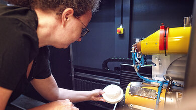 Eine Mitarbeiterin beim Einrichten einer CT-Messung des Brustoberflächenphantoms.