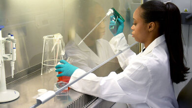 Fatima Kargbo befüllt eine Zellkulturflasche mit Kulturmedium.