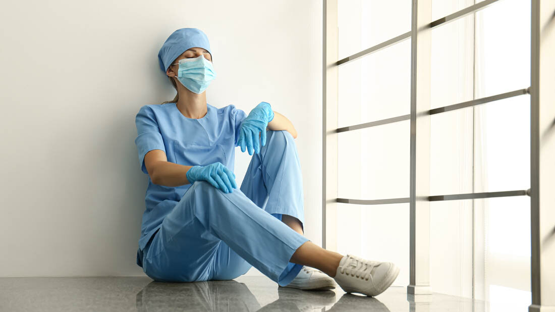 Medizinisches Personal sitzt am Boden und ist erschöpft