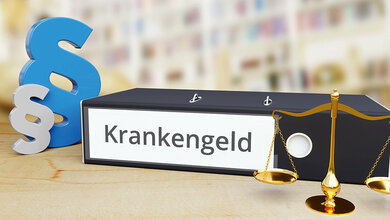 Symbole der Rechtsprechung: Paragrafenzeichen, Waage. Dazu ein Aktenordner, auf dessen Rücken steht: Krankengeld