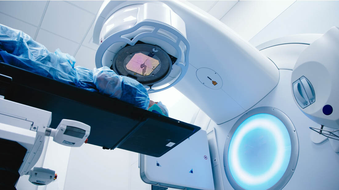 Ein Patient liegt unter einem Strahlentherapiegerät. 