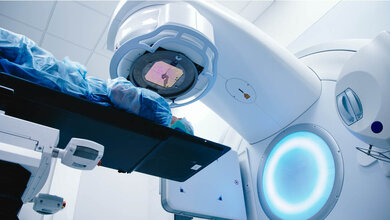 Strahlentherapie_Hautschaden_verhindern.jpg Ein Patient liegt unter einem Strahlentherapiegerät.