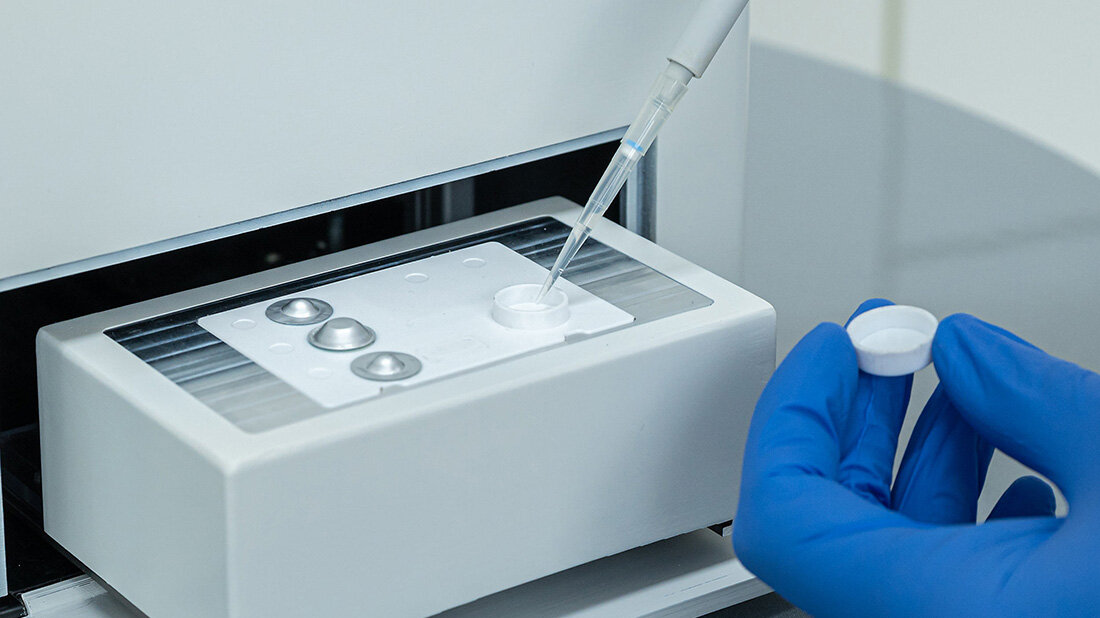 Mikrofluidische Plattform, eine Pipette trägt etwas auf den Träger auf