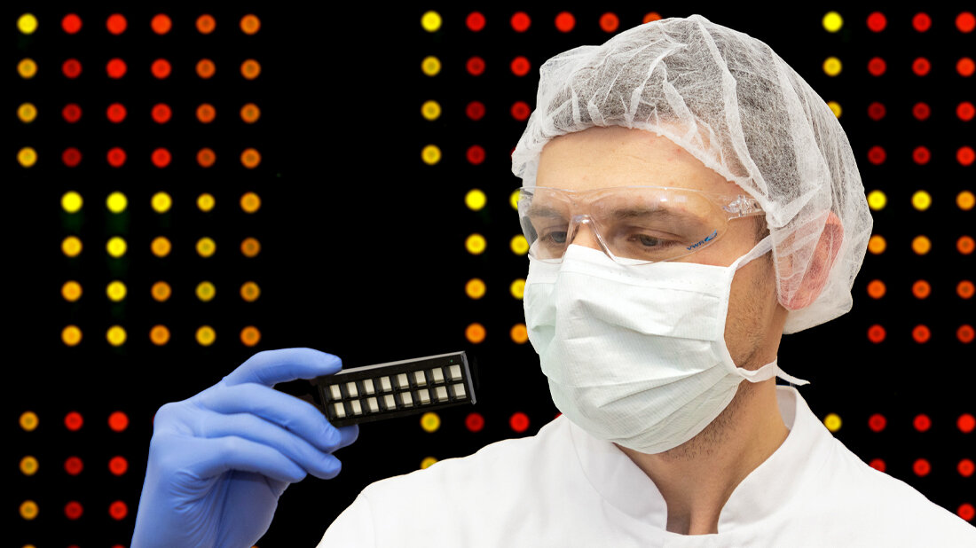 Forscher hält eine Halterung mit Microarray-Chips