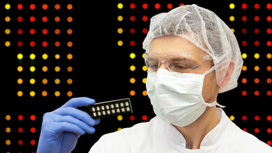 Forscher hält eine Halterung mit Microarray-Chips