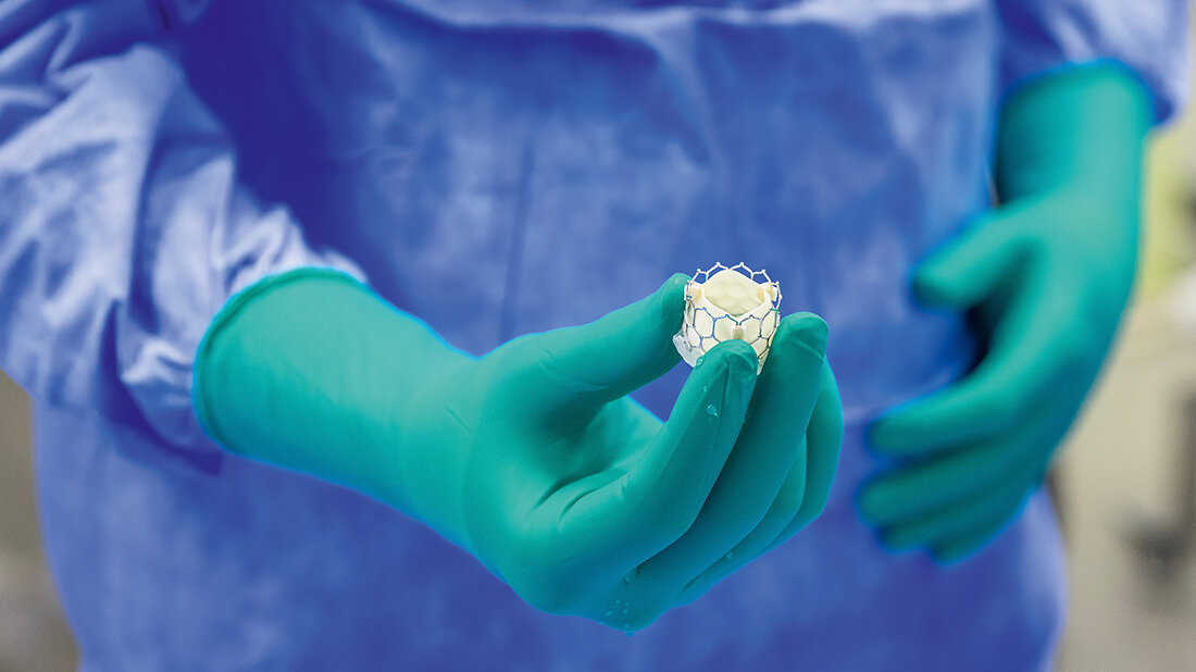 Foto einer künstlichen Aortenklappe in der Hand eines Chirurgen