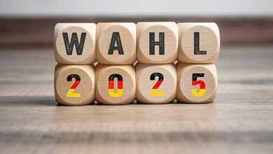 Foto mit Visualisierung der Wahl 2025 mittels Holzwürfeln mit Buchstaben und Ziffern