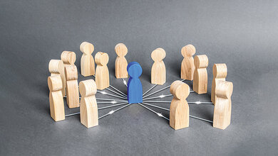 Foto einer symbolischen Darstellung der Rolle einer Führungskraft mithilfe von Holzfiguren