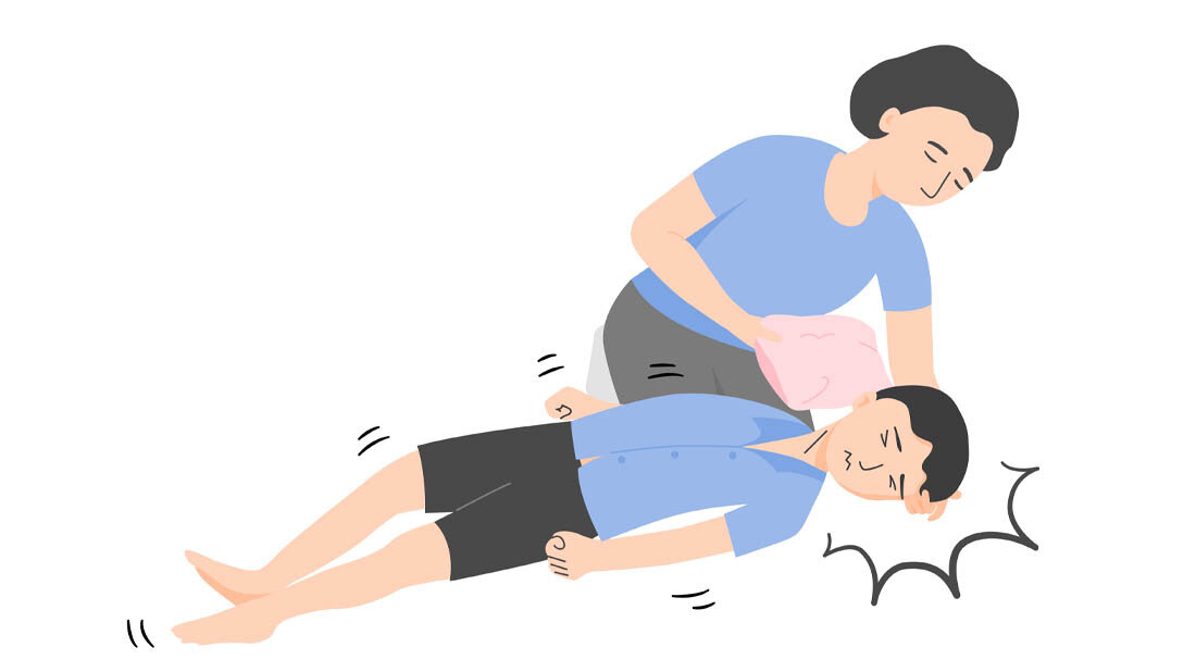 Symbolbild für einen Jungen mit epileptischem Anfall, der von einer weiblichen Person gestützt wird.