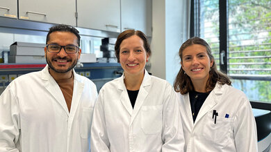 Drei Forschende in Kitteln im Labor: Moutaz Helal, Angela Riedel und Greta Mattavelli