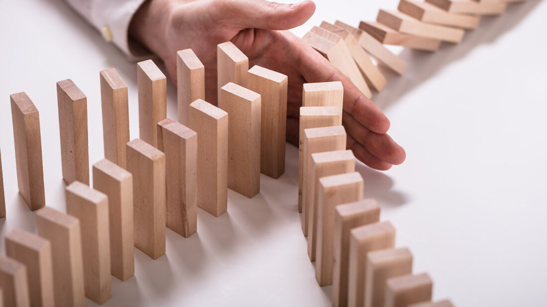 Eine Hand hält Dominosteine auf.