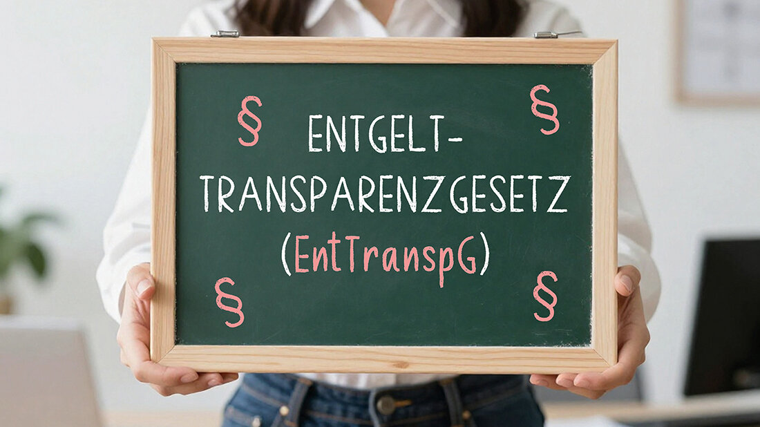 Was bringt das Entgelttransparenzgesetz (EntgTranspG) für Sie? Eine Frau hält eine Tafel in den Händen, auf der steht: Entgelttransparenzgesetz (EntgTranspG)
