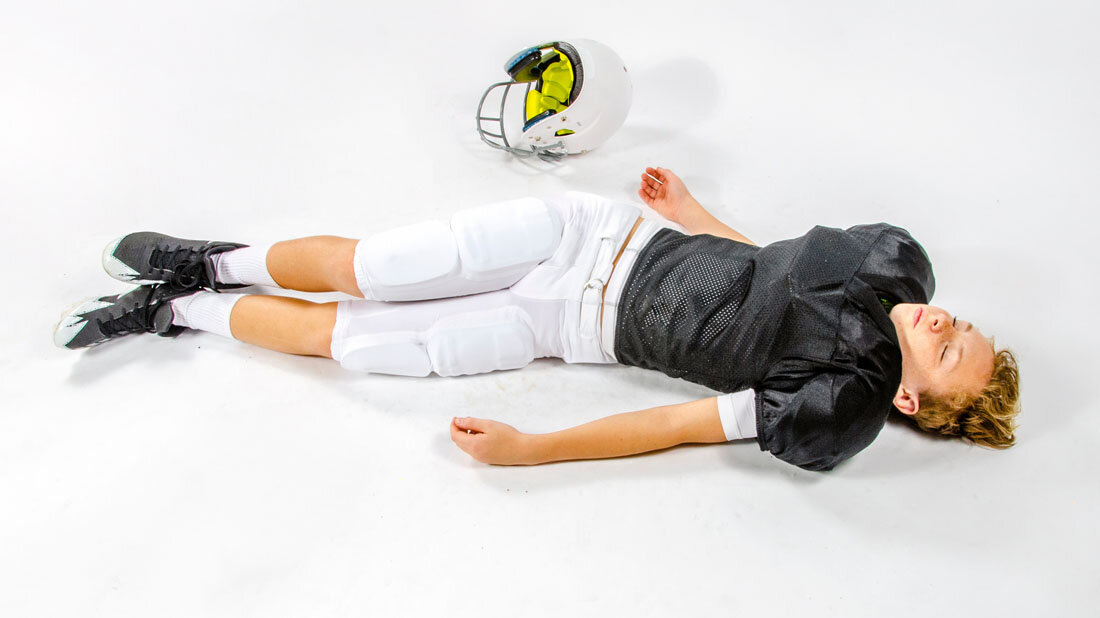 Footballspieler liegt am Boden