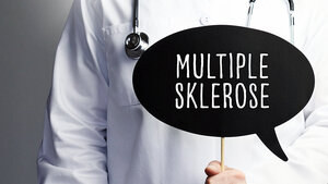 Eine Person in Medizinerkleidung und mit Stethoskop hält ein Schild in der Form einer Sprechblase vor sich, auf dem „Multiple Sklerose“ steht.