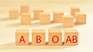 Foto von Holzwürfeln, die die Buchstaben für die Blutgruppen A, B, 0 und AB tragen