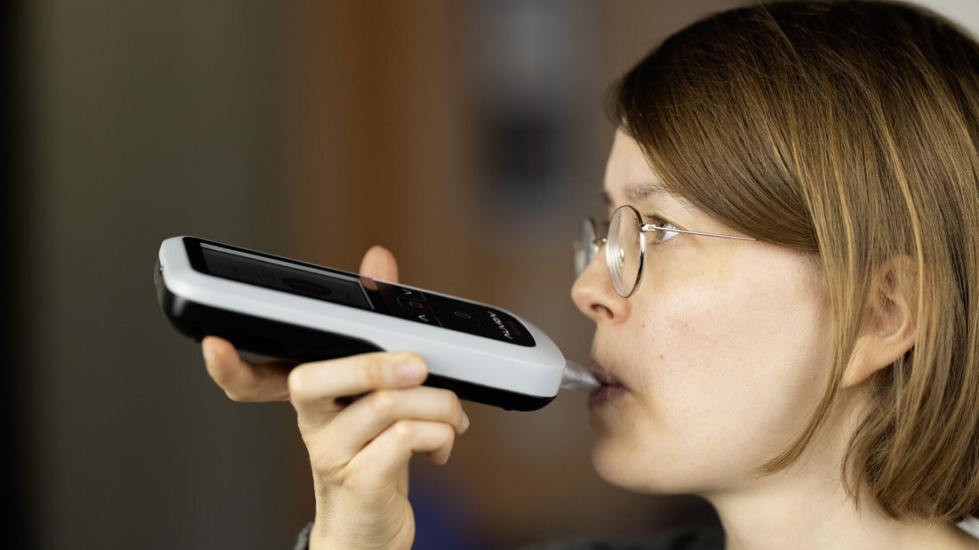 Fettverbrennung_Aceton.jpg Nutzerin führt mit dem smartphoneunterstützten Aceton-Atemanalysator eine Messung durch.