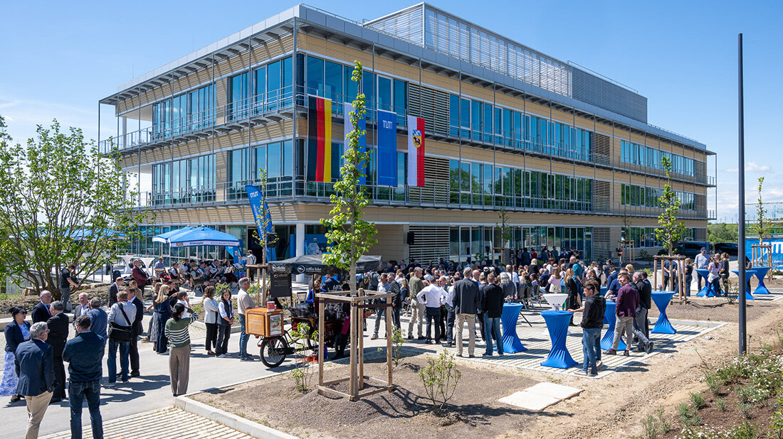 Einweihung_Zentrum_Infektionspraevention.jpg Menschen stehen draußen bei Sonnenschein vor einem Gebäude.
