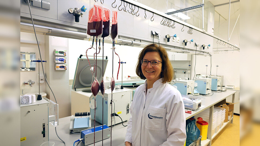 KonstanzeAurich_UnimedizinGreifswald.jpg Forscherin im Labor in weißem Kittel vor Geräten und drei Blutkonserven.