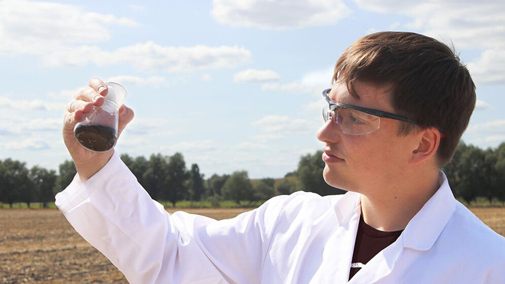 Wissenschaftler entnimmt eine Bodenprobe