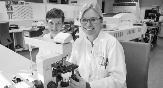 2 Laborantinnen vor einem Mikroskop