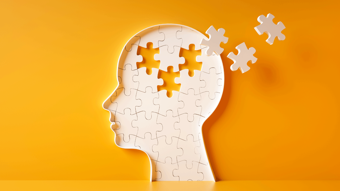 Dieses Bild zeigt eine symbolische Darstellung eines menschlichen Kopfes, der aus Puzzleteilen besteht. Einige Teile fehlen oder schweben außerhalb des Kopfes.