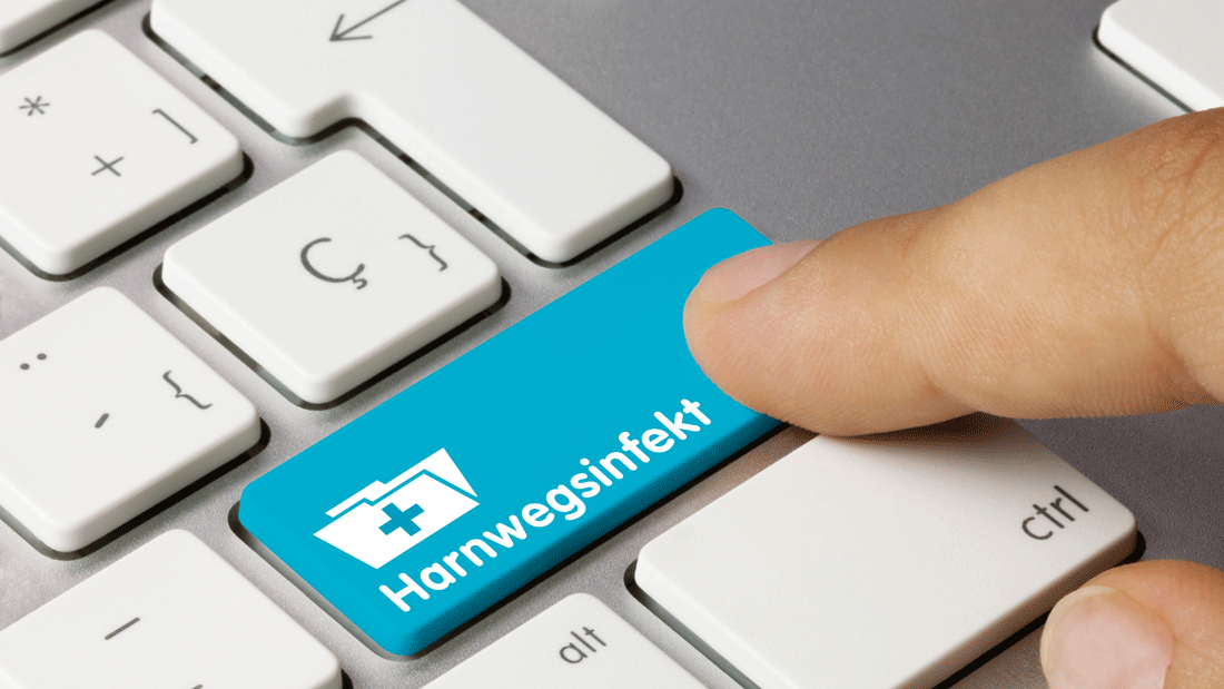 Ein Finger drückt auf einer Tastatur die blaue Taste „Harnwegsinfekt“.