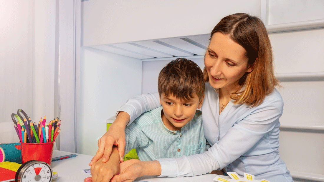 Dieses Bild zeigt eine erwachsene Person, die einem Kind bei einer kreativen Aktivität hilft, möglicherweise beim Basteln oder Zeichnen. Auf dem Tisch liegen bunte Stifte, Papier und ausgeschnittene Formen wie Schneeflocken, Wolken und Regenbögen.