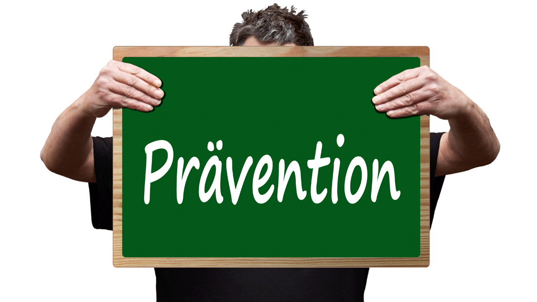 Das Bild zeigt eine Person, die ein grünes Schild mit der Aufschrift "Prävention" hochhält.