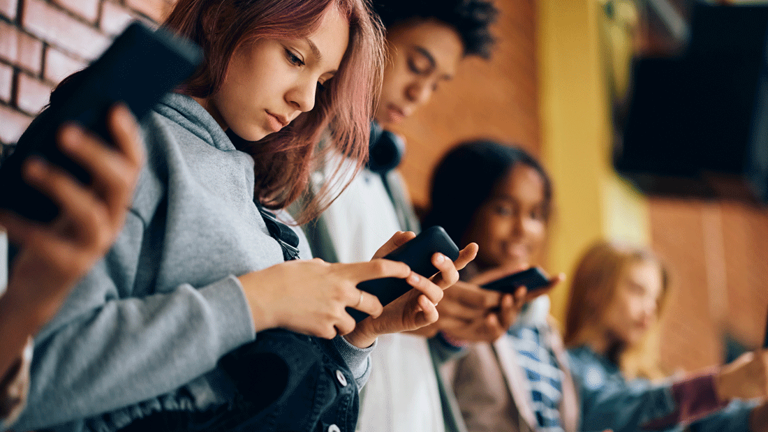 Dieses Bild zeigt eine Gruppe von Personen, die Smartphones in den Händen halten und benutzen. Der Fokus liegt auf ihren Händen und den Geräten, während die Gesichter aus Datenschutzgründen unkenntlich gemacht wurden. 
