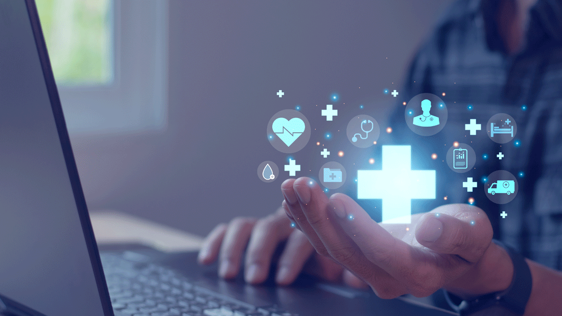 Dieses Bild zeigt eine Person, die an einem Laptop arbeitet, während digitale Symbole aus dem Bereich Gesundheit und Medizin über ihrer Hand schweben. Zu sehen sind Symbole wie ein Herz, ein Stethoskop, ein Krankenwagen und ein Krankenhausbett, die auf moderne digitale Gesundheitslösungen hinweisen. 