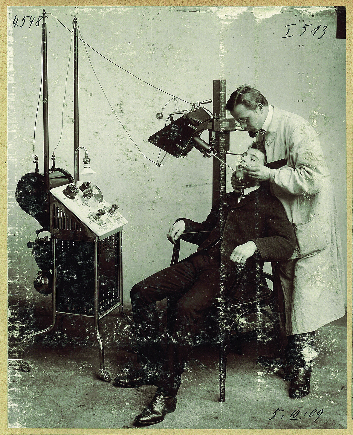 Historisches Foto, das den Einsatz eines Röntgengeräts im Rahmen eine zahnärztlichen behandlung zeigt