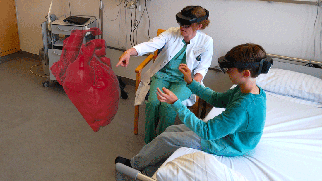 Ein Kind und eine Wissenschaftlerin des HoloHeart-Projekt-Teams im Uniklinikum Heidelberg beim Testen der HoloHeart-Software am Modell eines Kinderherzens.